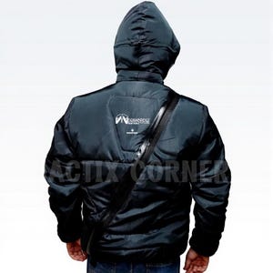 May include: A black hooded jacket with a quilted design, featuring a logo on the upper back and a black strap across the chest. The jacket has a zipper closure and is worn by a person. The text "ACTIX CORNER" is visible.