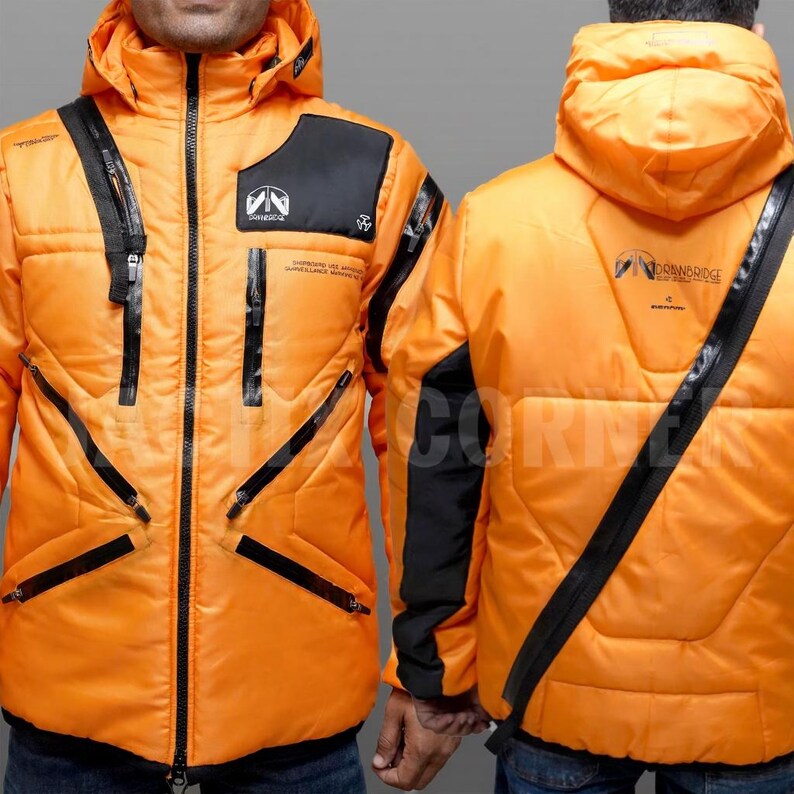 May include: Bright orange puffer jacket with a hood and black accents. Features multiple zippered pockets and a black panel on the upper chest. The jacket has a logo on the chest and back, and black diagonal stripes.