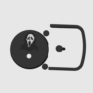 May include: A black belt buckle featuring a circular design with the iconic Ghostface mask from the Scream horror film series. The buckle has a rectangular frame and a pin for closure.