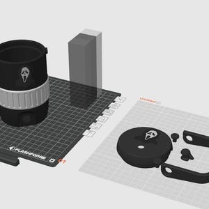 May include: A black and white tumbler with a Ghostface design, a white band, and a black handle. The tumbler is on a black Flashforge surface, with other 3D printed parts.