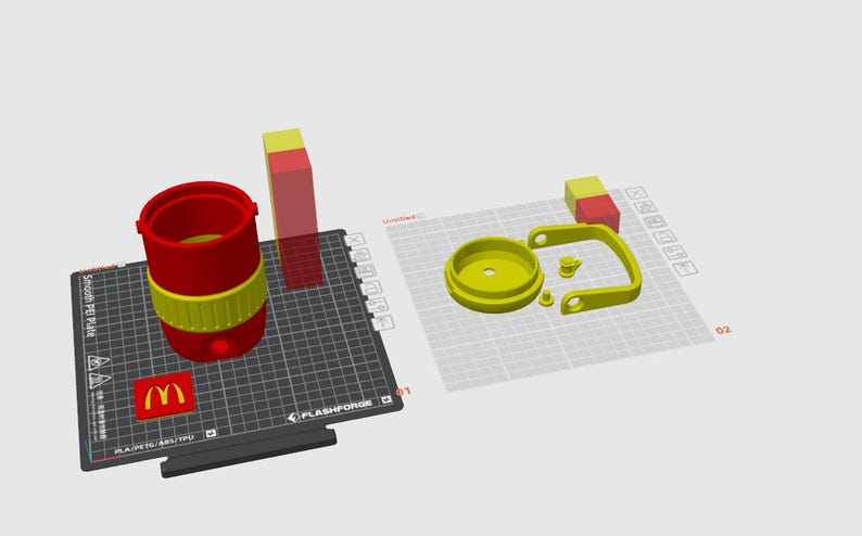 May include: A 3D-printed red and yellow tumbler with a handle and lid, along with a separate red and yellow block. The McDonald's logo is visible on a black surface. The tumbler is disassembled.