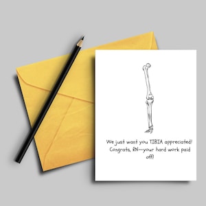 May include: A humorous greeting card with a black and white illustration of a human leg bone. The text reads "We just want you TIBIA appreciated! Congrats, RN-your hard work paid off!"