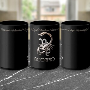 May include: Three black coffee mugs with a scorpion design and the word "Scorpio" printed on the front. The mugs have different text printed on the back, including "Passionate, Determined, Loyal", "Loyal, Ambitious, Brave", and "Brave, Strategic, Resourceful".