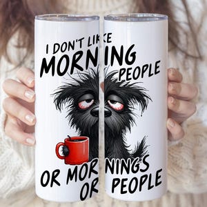 Könnte beinhalten: Weißer Becher mit dem Text "I don't like morning people or mornings or people". Eine Illustration eines müden, schwarzen, zotteligen Hundes mit roten Augen und einer roten Kaffeetasse.