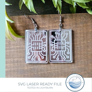 May include: Clear acrylic earrings with a circuit board design, hanging from silver-colored hooks. The earrings are rectangular with etched lines and circles. The text "SVG LASER READY FILE TESTED IN LIGHTBURN" is at the bottom.