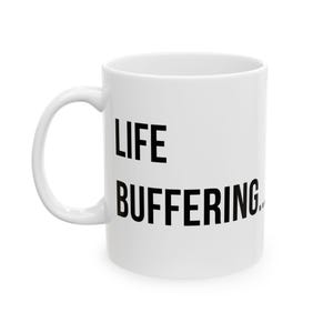 May include: White ceramic mug with the words "LIFE BUFFERING..." printed in black. The mug has a curved handle and a cylindrical shape. The text is centered on the mug.