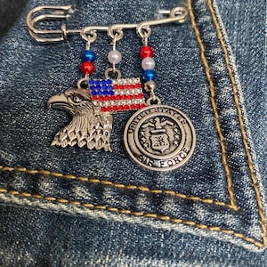 United States Air Force Safety Pin with a Stunning Air Force Charm, plus a Silver Eagle, a US Flag and red, white and blue beads.