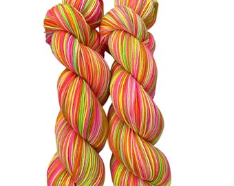 Peut inclure: Deux écheveaux de fil coloré avec un motif rayé. Le fil présente un mélange vibrant de rose, d'orange, de jaune et de vert. Le fil est bien enroulé et prêt pour les projets de création. Le fond est blanc uni.