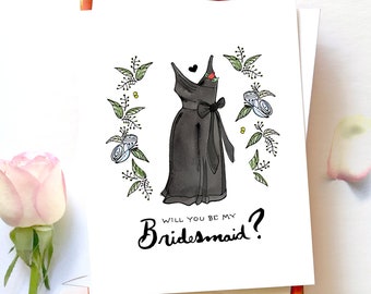 Puede incluir: Una tarjeta blanca con una ilustración en blanco y negro de un vestido con una flor roja en el corpiño. El vestido está rodeado de una corona de hojas verdes y flores blancas. El texto "Will you be my Bridesmaid?" está escrito en cursiva negra.