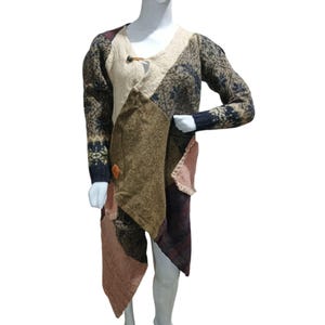Può includere: Un maglione patchwork dal design unico. Il maglione presenta un mix di trame e colori, tra cui beige, marrone e blu navy. Ha una chiusura con bottoni e un orlo asimmetrico. Le maniche hanno un design a fantasia.