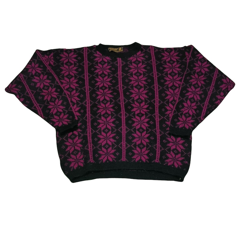 May include: A black and fuchsia-colored sweater with a snowflake pattern. The sweater has a crew neck and long sleeves. The snowflake design is vertically aligned and covers the front and sleeves.