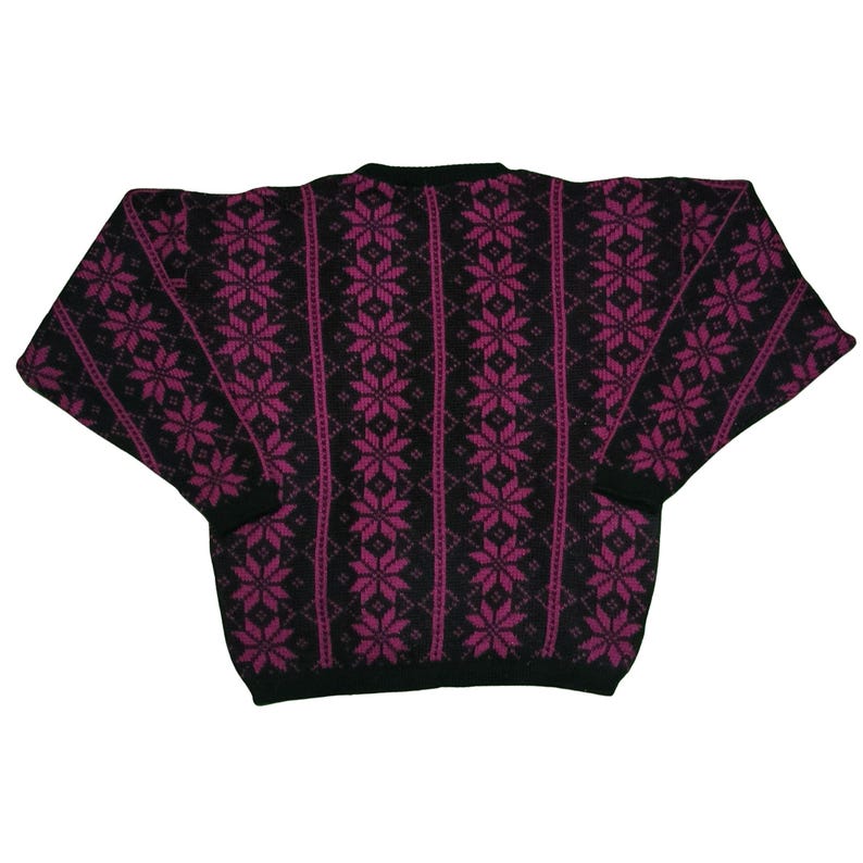 May include: A black sweater with a magenta snowflake pattern. The sweater has a crew neck and long sleeves. The snowflake design is vertically aligned and covers the entire front and back of the sweater.