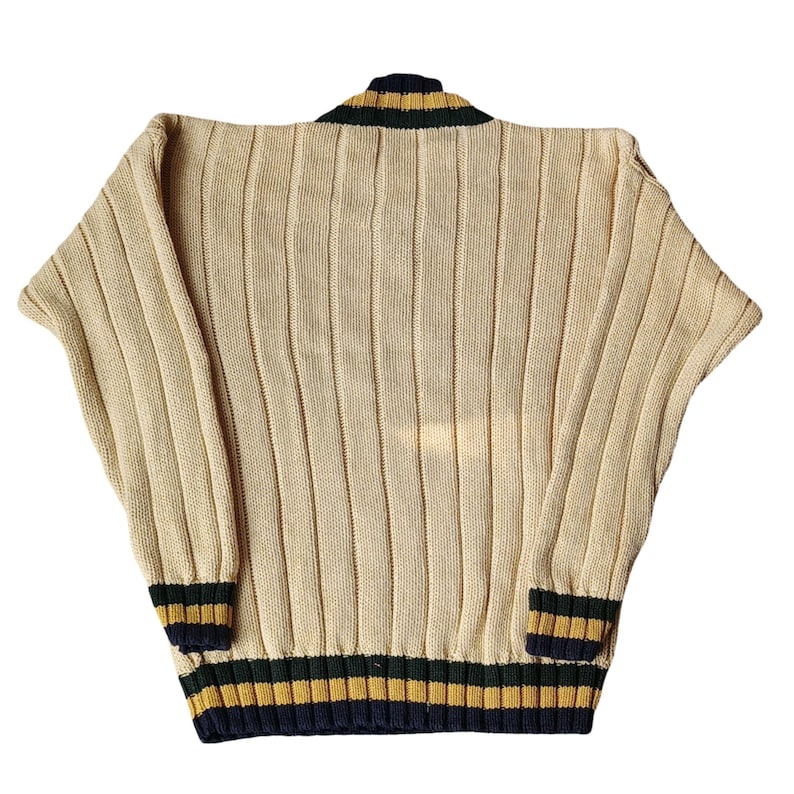 May include: Cream-colored knit sweater with vertical ribbing. The collar and cuffs feature navy blue, green, and gold stripes. The sweater has a relaxed fit and a classic, vintage style.