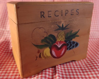 May include: A wooden recipe box with a painted design of fruit and the word "RECIPES" on the front.