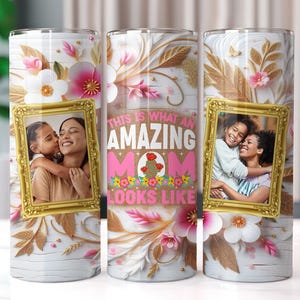 May include: A white tumbler with a floral design and gold accents. The tumbler features a photo of a mother and daughter with the text "This is what an amazing mom looks like".