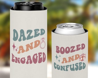 May include: Two white can coolers with a retro design. The left cooler says "Dazed and Engaged" with a diamond ring. The right cooler says "Boozed and Confused" with a disco ball.