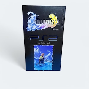 Op de afbeelding: Een zwarte PlayStation 2-gamecase met een blauwe en gele afbeelding van de personages uit Final Fantasy X op de voorkant. De titel "Final Fantasy X" is in wit op de voorkant van de case gedrukt.
