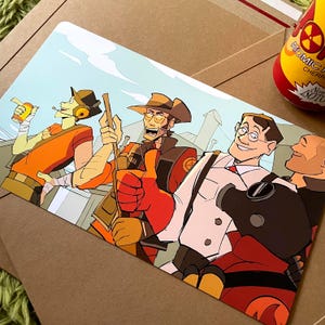 May include: A rectangular art print featuring a colorful cartoon illustration of four characters from Team Fortress 2. The group includes a scout with a drink, a sniper with a rifle, a medic in a white coat, and a pyro wearing a black gas mask.