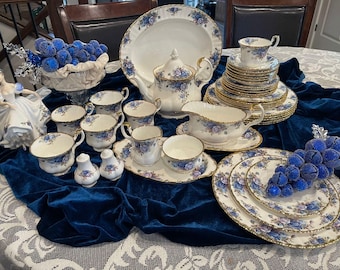 May include: A set of fine bone china teacups, saucers, and plates featuring a floral design in shades of blue and white. The set includes a teapot, creamer, sugar bowl, and a serving platter.