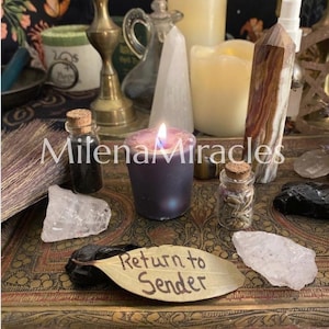 May include: A collection of ritual items on a decorative tray, including a lit purple candle, a brown and white crystal point, clear quartz, black stones, a small broom, glass vials with cork stoppers, and a leaf inscribed with Return to Sender.
