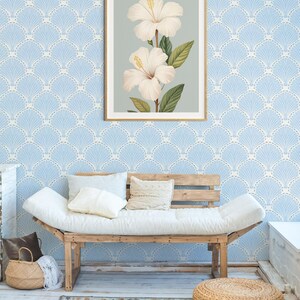 Pu&ograve; includere: Una stampa botanica incorniciata con due fiori di ibisco bianchi con stami gialli e foglie verdi. L'opera d'arte &egrave; ambientata su uno sfondo azzurro e incorniciata in una cornice di legno dorato. La stampa &egrave; esposta in una stanza con carta da parati azzurra.