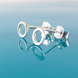 Op de afbeelding: Een paar zilveren oorbelletjes met een simpel rond ontwerp. De oorbelletjes zijn klein en delicaat, en zouden een geweldig cadeau zijn voor een vriend of geliefde.