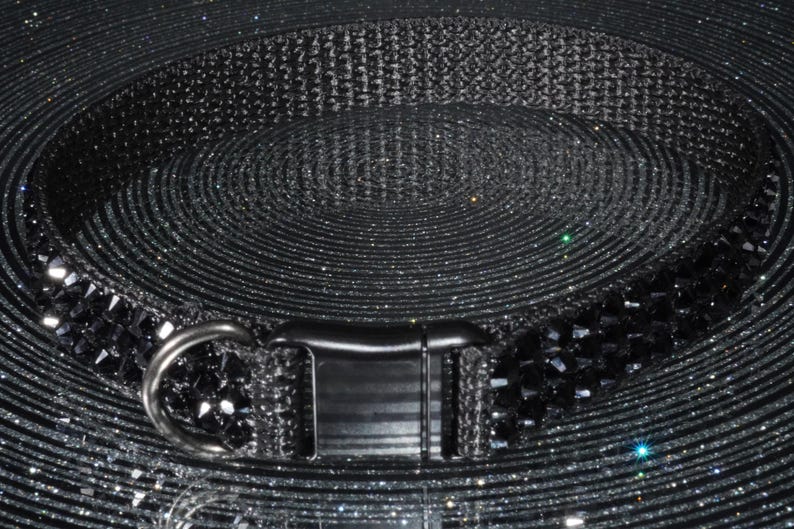 K&ouml;nnte beinhalten: Ein schwarzes Haustierhalsband mit einem funkelnden, edelsteinartigen Design. Das Halsband verf&uuml;gt &uuml;ber eine robuste Schnalle und einen Metall-D-Ring zur Befestigung der Leine. Das Halsband besteht aus einem strapazierf&auml;higen, gewebten Material.