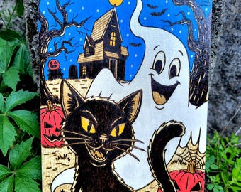 May include: Halloween-themed wooden art piece featuring a black cat with yellow eyes, a smiling ghost, and a haunted house under a starry blue sky. Carved pumpkins and bare trees complete the spooky scene.