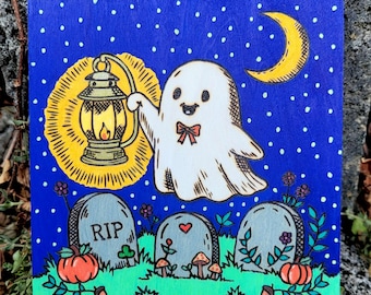 May include: A square wooden plaque featuring a hand-painted scene of a white ghost with a red bow tie holding a yellow lantern. The background is a dark blue starry night with a yellow crescent moon, green grass, three tombstones, and pumpkins.