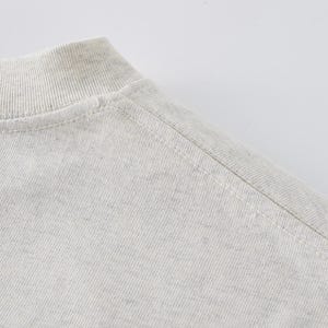 Heavyweight drop shoulder t-shirt size chart with unisex measurements, 425 GSM cotton details, care instructions, and fit guide.