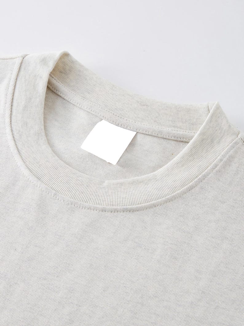 Heavyweight drop shoulder t-shirt size chart with unisex measurements, 425 GSM cotton details, care instructions, and fit guide.