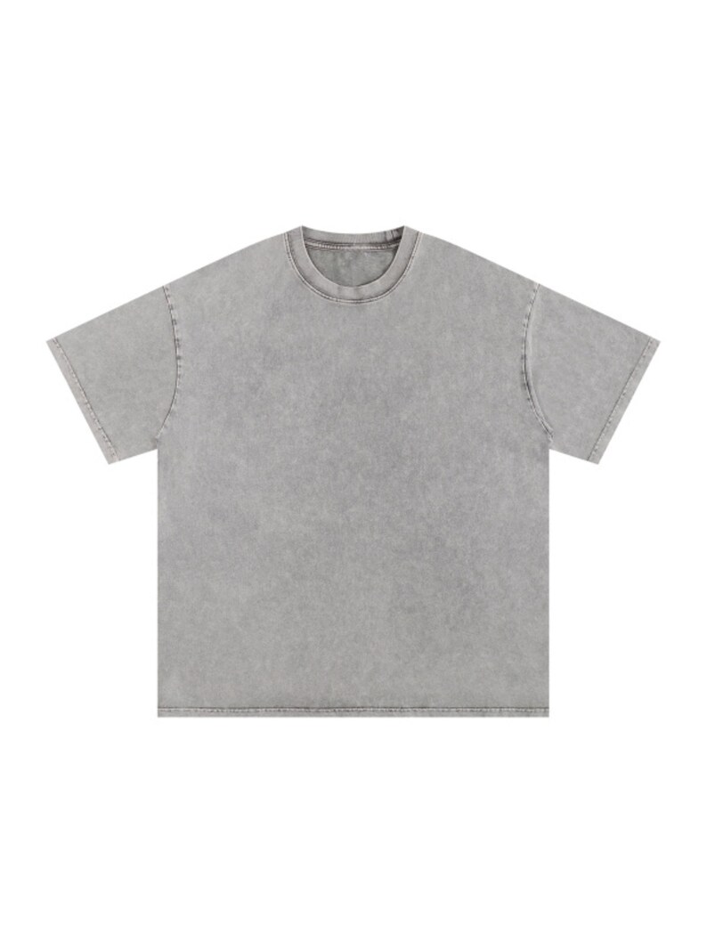 Op de afbeelding: Een t-shirt met korte mouwen in een effen, gedempte grijze kleur met een gewassen, vintage-stijl afwerking. Het kledingstuk heeft een klassieke ronde hals, een rechte zoom en een relaxte pasvorm met zichtbare stiksels bij de mouwen.