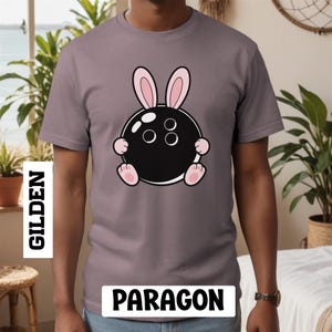 バニーボウリングボールTシャツ、ボウリングバニーシャツ、面白いイースターボウリングTシャツ、ピンクの耳のグラフィックトップ
