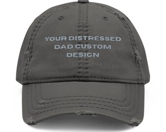 Op de afbeelding: Een grijze, distressed baseballcap met de tekst "YOUR DISTRESSED DAD CUSTOM DESIGN" in lichtgrijs geborduurd. De cap heeft een versleten uitstraling met gerafelde randen.