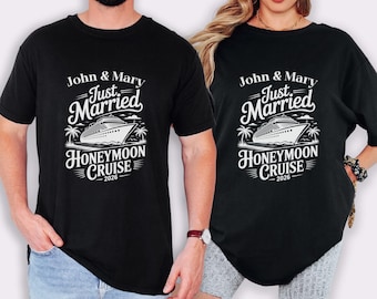 May include: Black t-shirts with a white graphic. The graphic reads "John & Mary Just Married Honeymoon Cruise 2026" with a cruise ship illustration. The shirts are casual and suitable for a couple.