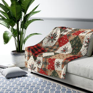May include: A patchwork throw blanket with a festive design. The blanket features squares of red, green, beige, and white fabric with snowflake and floral patterns. A section of the blanket has a red and black buffalo plaid pattern.