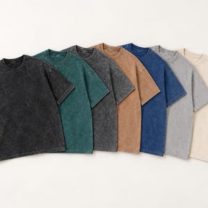 Seven blank acid wash oversized T-shirts in black, dark green, Pirate Gray, light brown, dark blue, light gray, and apricot.