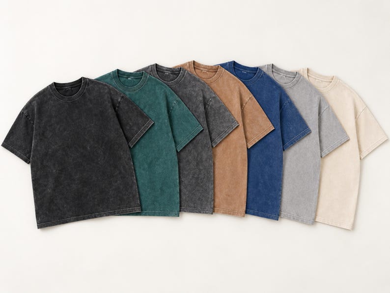 Seven blank acid wash oversized T-shirts in black, dark green, Pirate Gray, light brown, dark blue, light gray, and apricot.