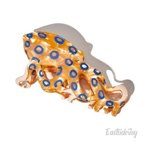 May include: A yellow and blue octopus figurine with a blue and white patterned design. The octopus is made of a shiny, translucent material.