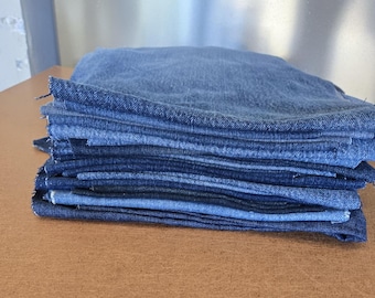 Könnte beinhalten: Ein Stapel Jeansstoff in verschiedenen Blautönen, von hell bis dunkel.