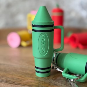 May include: Green crayon-shaped keychain with a black handle and the text "MR. BEALS" embossed on the side.