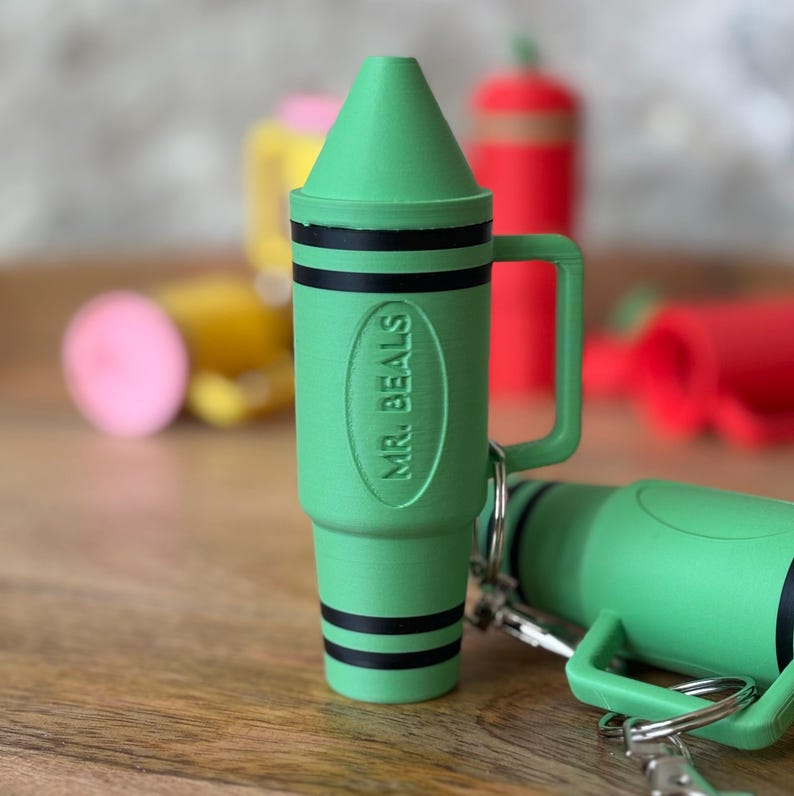 May include: Green crayon-shaped keychain with a black handle and the text "MR. BEALS" embossed on the side.
