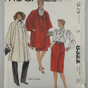 May include: A McCalls 8322 sewing pattern envelope featuring illustrations of three outfits: a white cape with black trousers, a red cape with a matching skirt, and a white long-sleeved blouse with a red skirt. The text includes Halston and 8322.