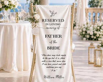 May include: A cream-colored fabric memorial chair cover draped over a gold chair, featuring a black printed dove, the text RESERVED IN LOVING memory of FATHER of the BRIDE, a memorial poem, and the name William Miller, accented with a white rose.