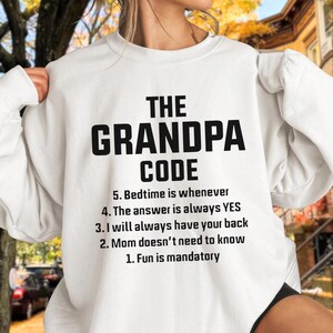 May include: White sweatshirt with the text "THE GRANDPA CODE" in bold black letters. Below the title are five rules, including "Fun is mandatory" and "The answer is always YES."