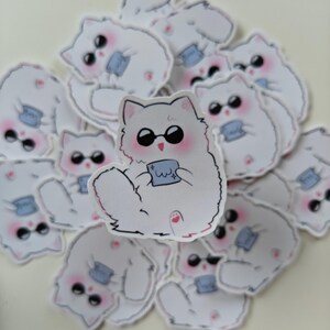 Cute anime cat sticker featuring a fluffy chibi-style Gojo Satoru design with sunglasses and a tiny cloth. A perfect Jujutsu Kaisen-themed vinyl sticker for fans to decorate water bottles, laptops, sketchbooks, and journals!