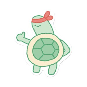 May include: A sticker of a cartoon turtle with a green shell and body, wearing a red headband. The turtle is giving a thumbs-up gesture with its left hand. The shell has a light beige border.