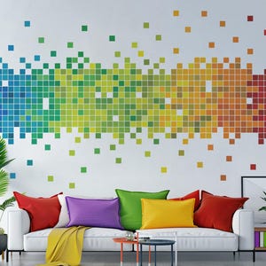 May include: A white sofa with colourful cushions in red, green, purple and yellow. The wall behind the sofa has a rainbow pixel design.