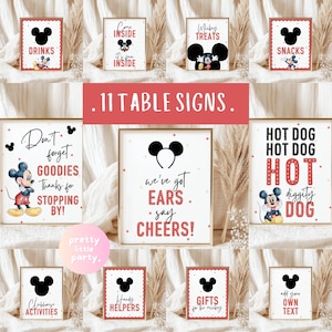Puede incluir: Una colección de 11 letreros de mesa enmarcados con un tema de Mickey Mouse. Los letreros incluyen frases como "Bebidas", "Snacks" y "Hot Dog". Los letreros tienen un esquema de color rojo y negro con un fondo blanco. Se muestra el texto "11 Letreros de mesa".