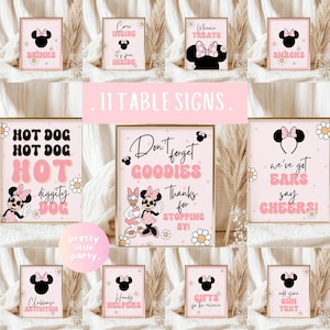 May include: A collection of eleven framed pink signs with Minnie Mouse-themed designs. The signs feature phrases like "Drinks," "Hot Dog," and "Goodies," along with Minnie Mouse illustrations and daisy accents. The signs are suitable for a party.
